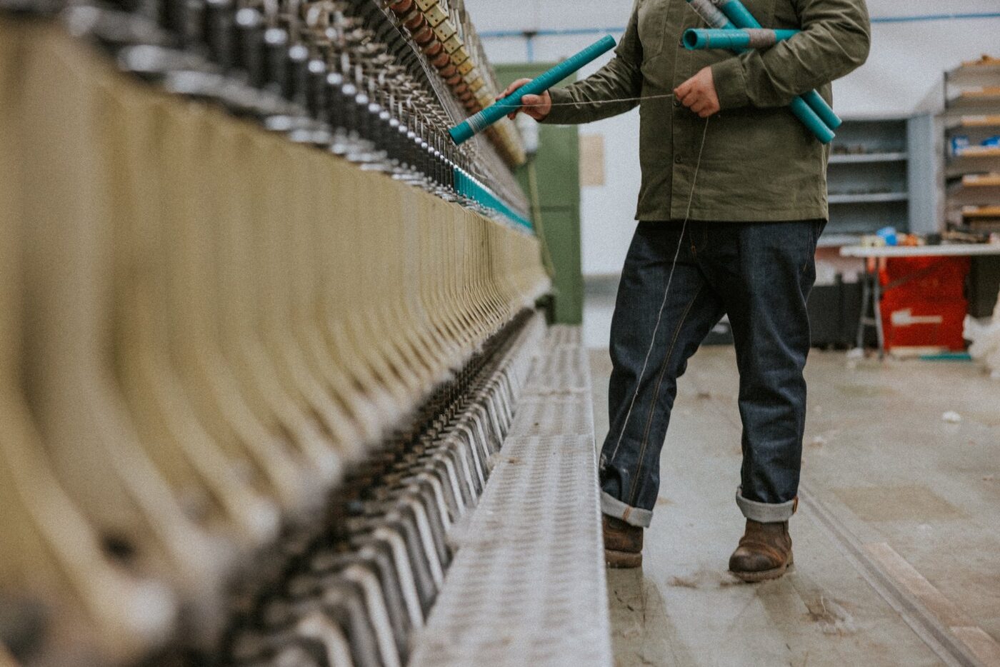 A member of the team carrying wound bobbins across the mill floor